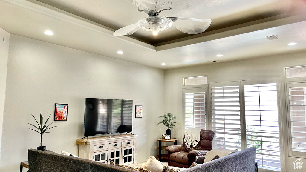 Living room with a raised ceiling and ceiling fan