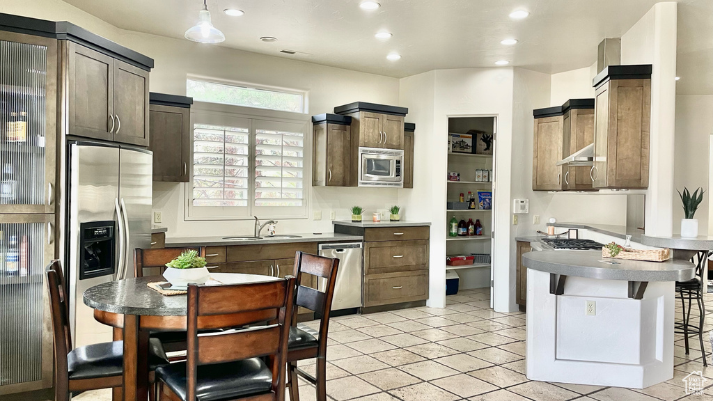 Kitchen featuring light tile floors, stainless steel appliances, and sink