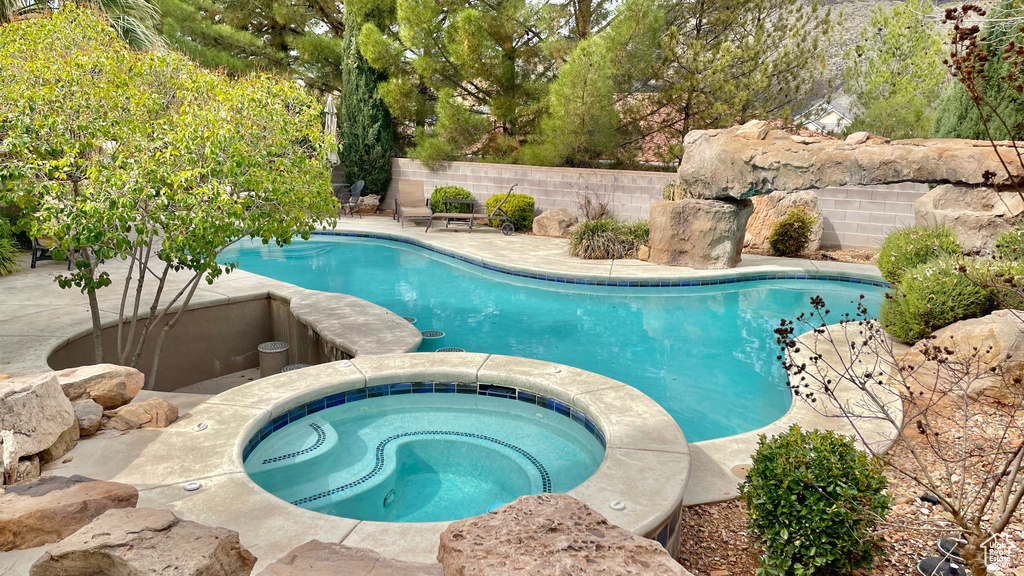 View of pool with an in ground hot tub