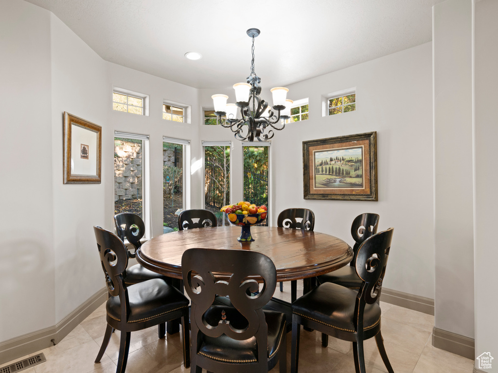 Dining room with light tile floors and a chandelier