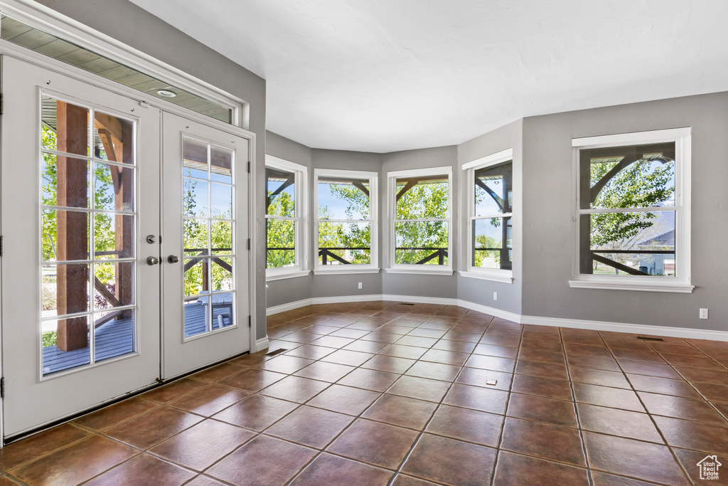 Unfurnished sunroom featuring french doors