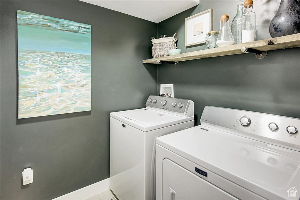 Laundry room featuring tile floors and washing machine and clothes dryer