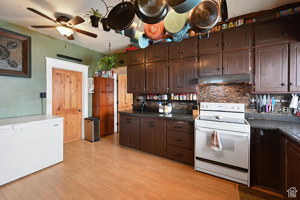 Kitchen featuring light hardwood / wood-style flooring, ceiling fan, backsplash, and white range with electric cooktop