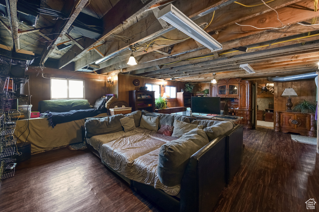 Living room with dark hardwood / wood-style floors and wood walls