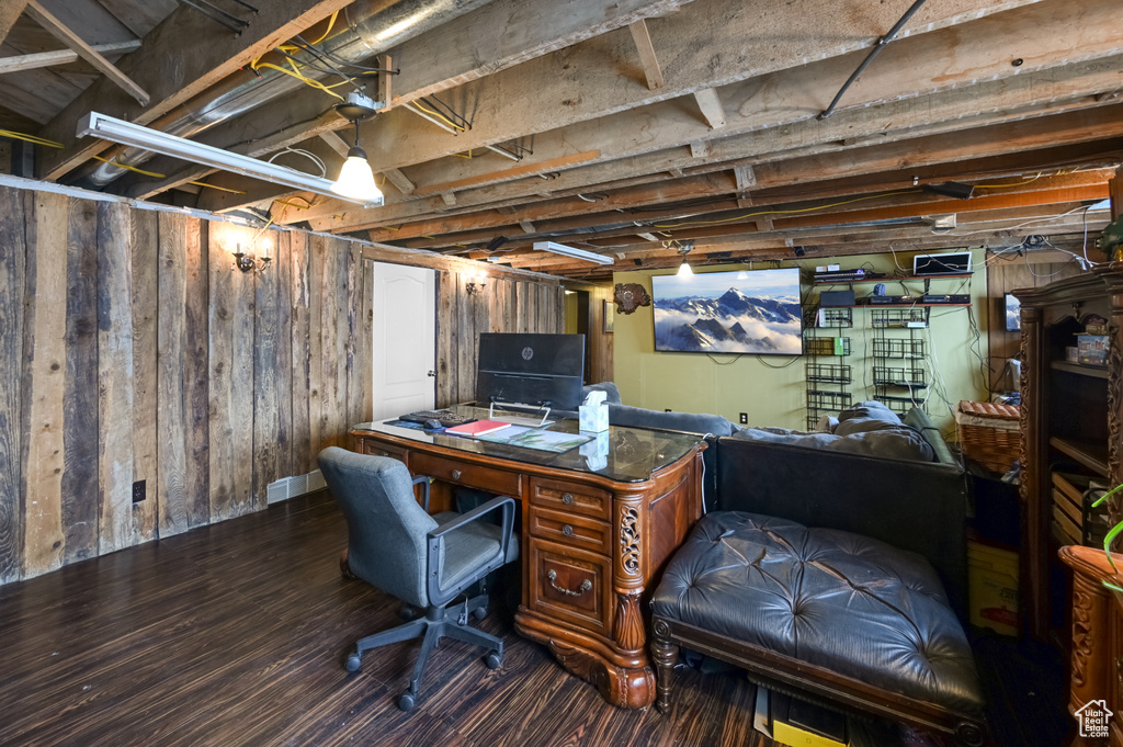 Home office featuring dark hardwood / wood-style floors and wood walls