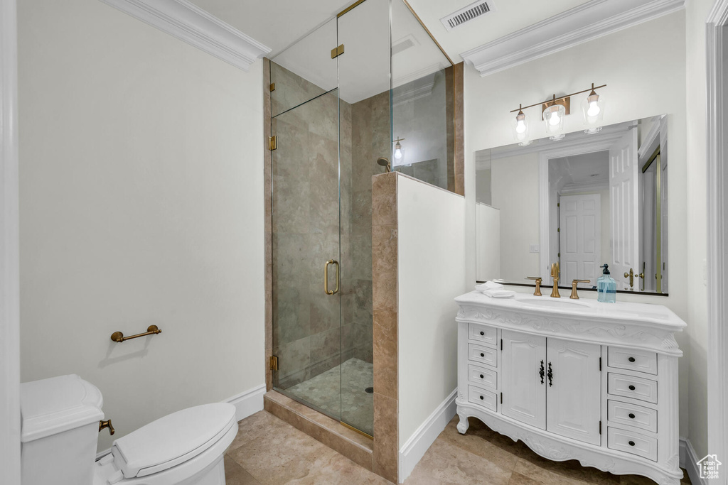 Bathroom with vanity with extensive cabinet space, an enclosed shower, tile floors, and toilet