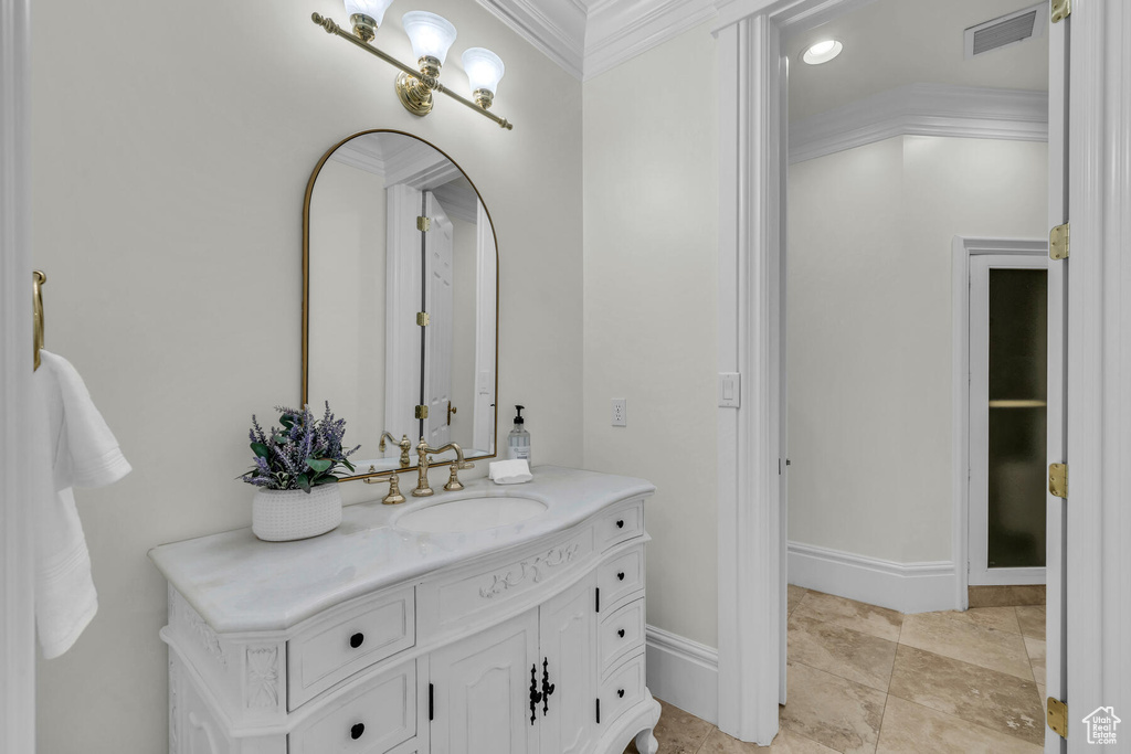 Bathroom with crown molding, vanity, and tile flooring