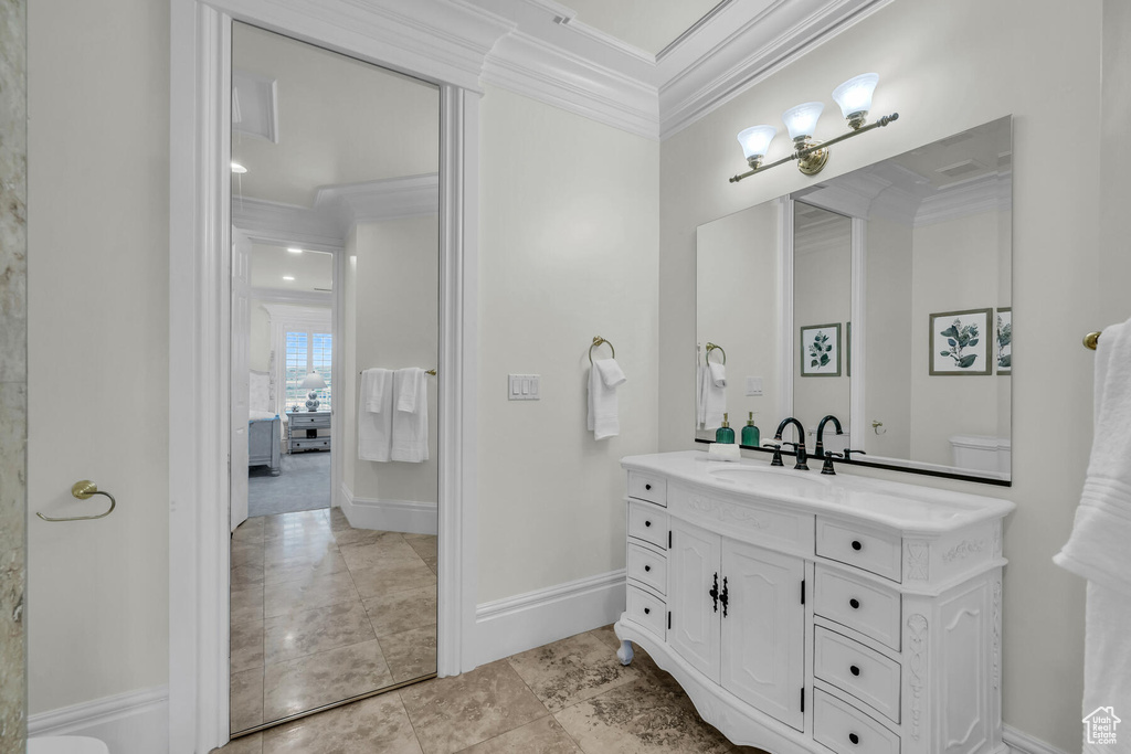 Bathroom featuring crown molding, toilet, oversized vanity, and tile flooring