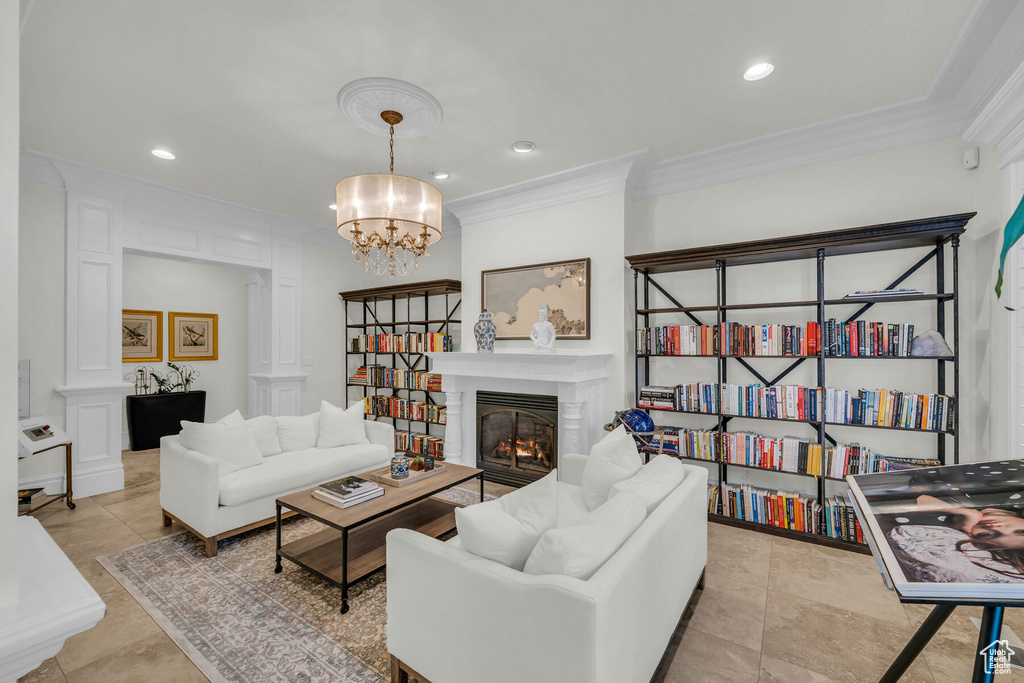 Living room featuring light tile flooring, crown molding, and a notable chandelier