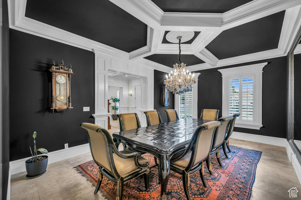 Tiled dining room with coffered ceiling, ornate columns, an inviting chandelier, and ornamental molding