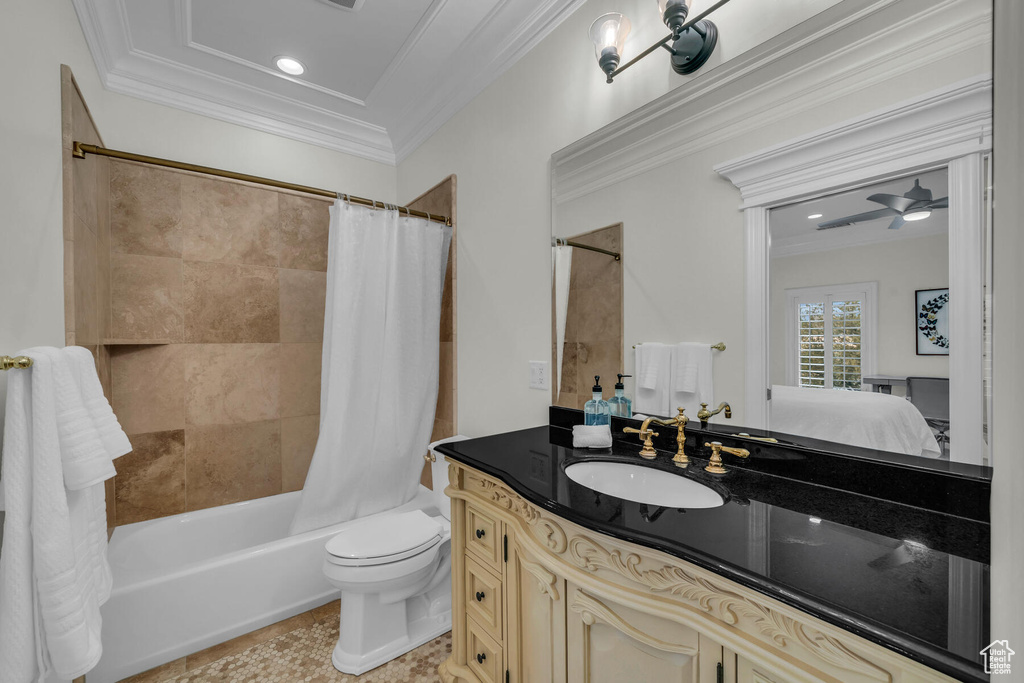 Full bathroom with shower / bath combo with shower curtain, oversized vanity, toilet, crown molding, and ceiling fan