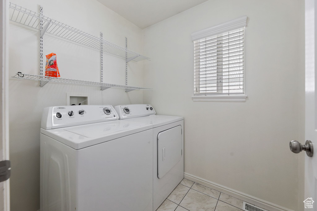 Washroom featuring light tile floors, hookup for a washing machine, and independent washer and dryer