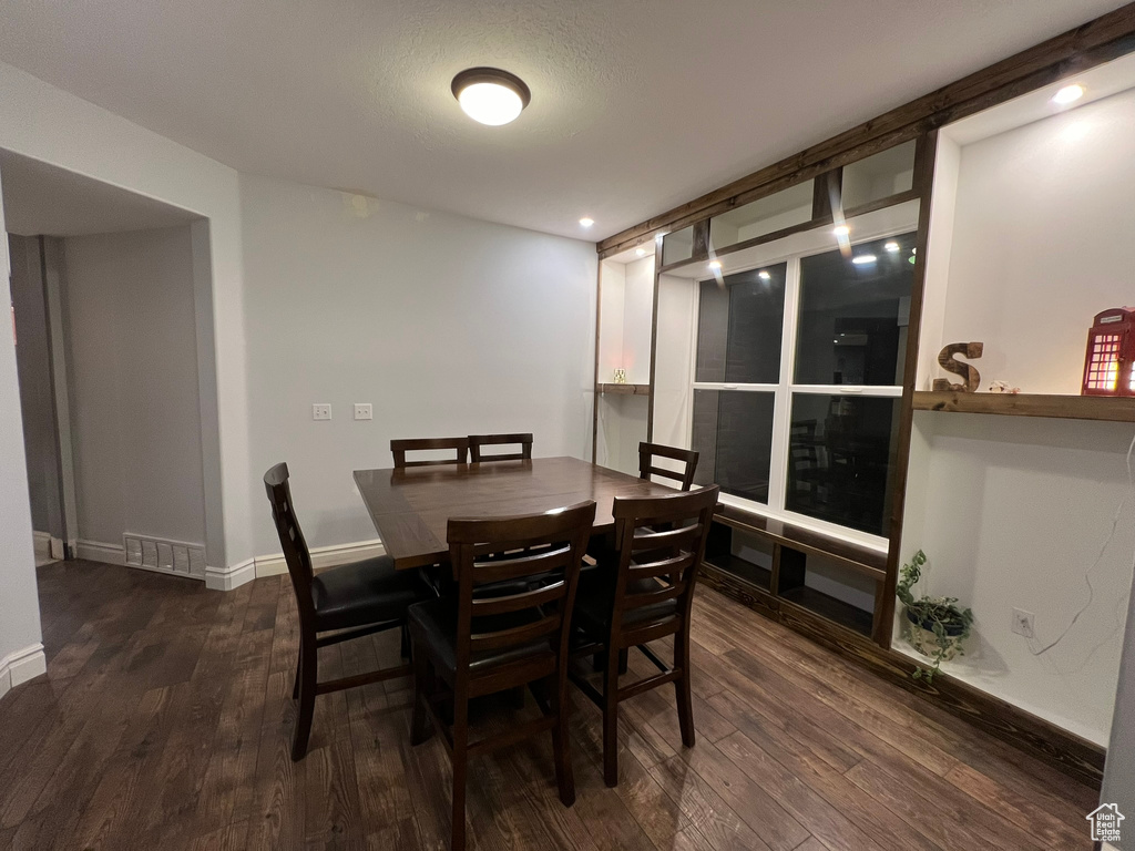 Dining space with dark wood-type flooring