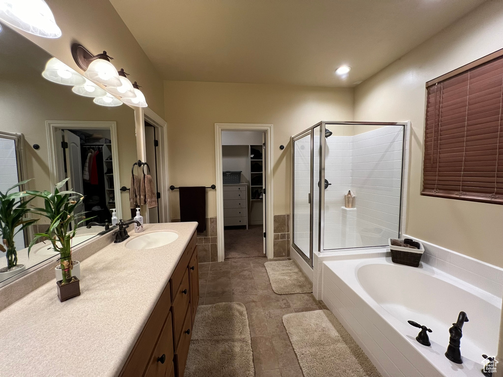 Bathroom featuring large vanity, plus walk in shower, and tile flooring