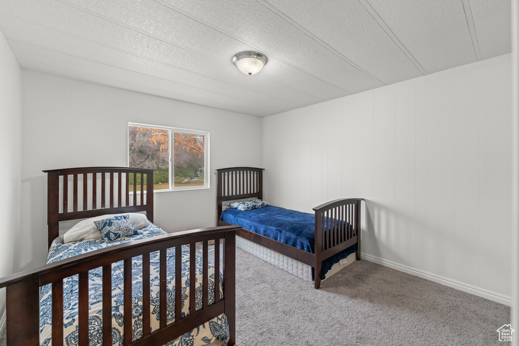 Bedroom with light colored carpet and a textured ceiling