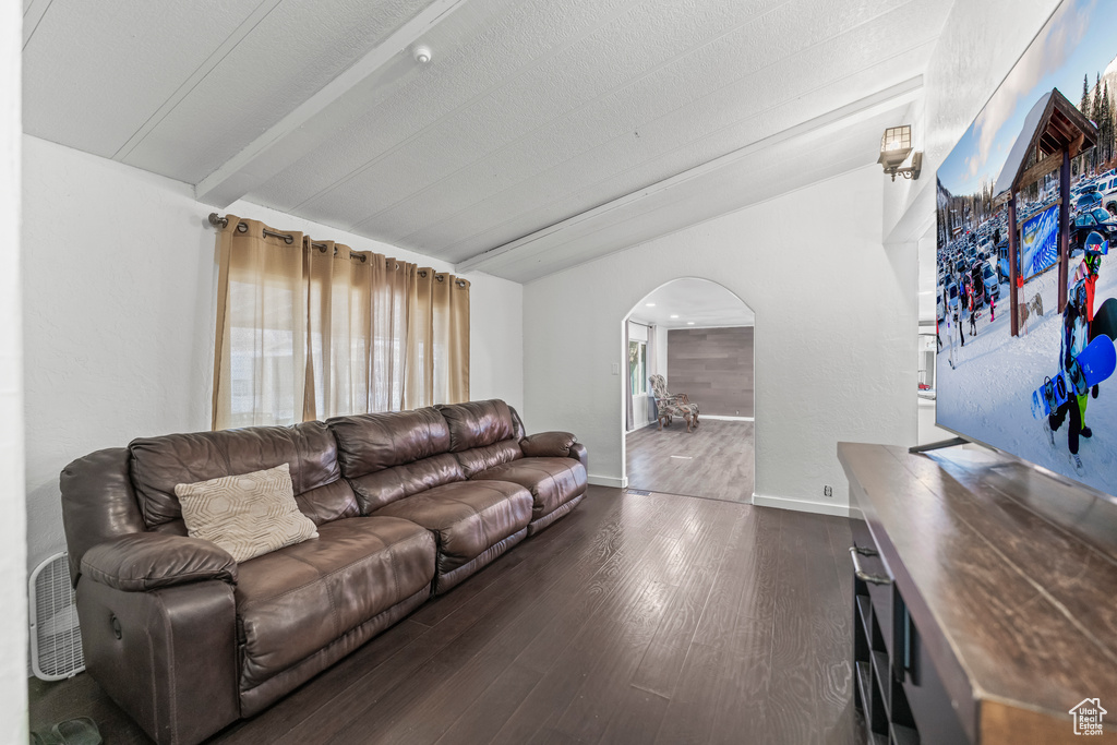 Living room featuring dark hardwood / wood-style flooring and beam ceiling