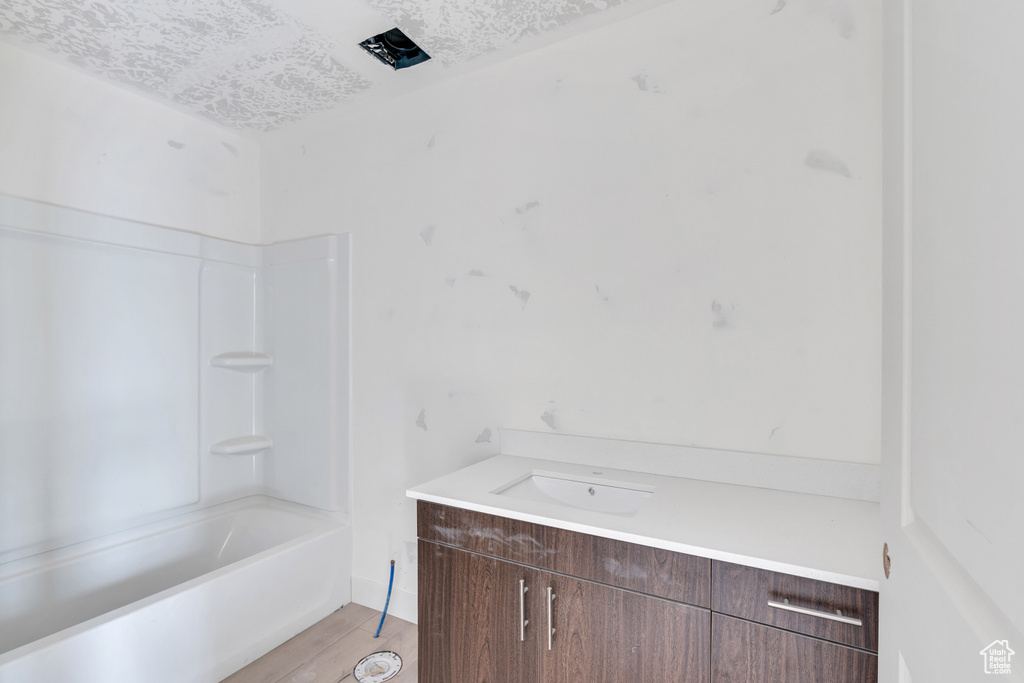Bathroom featuring vanity, a textured ceiling, and shower / bathing tub combination