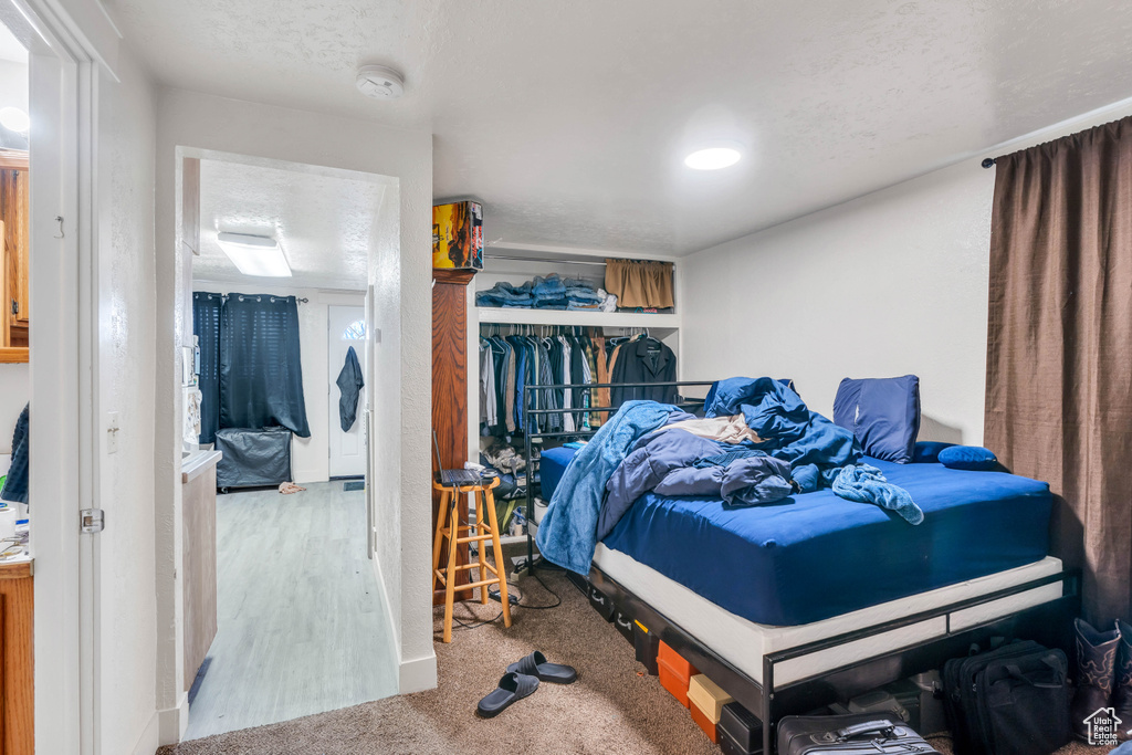 Bedroom with light hardwood / wood-style floors, a closet, and a textured ceiling