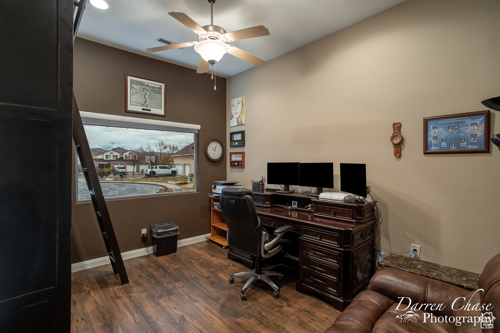 Office with dark hardwood / wood-style floors and ceiling fan
