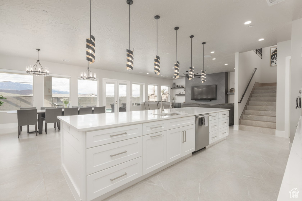 Kitchen with dishwasher, white cabinetry, sink, a chandelier, and light tile flooring