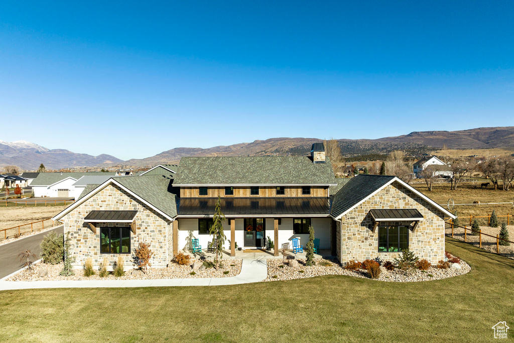 View of front of house with a front yard and a mountain view