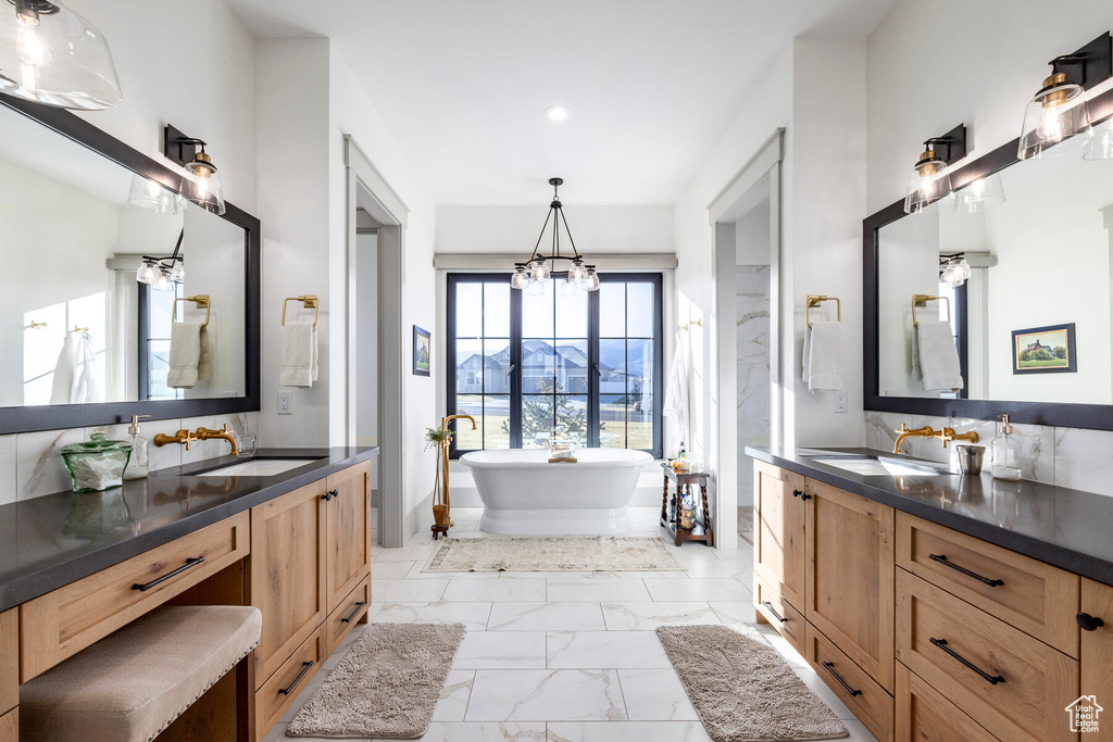 Bathroom featuring a mountain view, dual vanity, a notable chandelier, a bath, and tile flooring