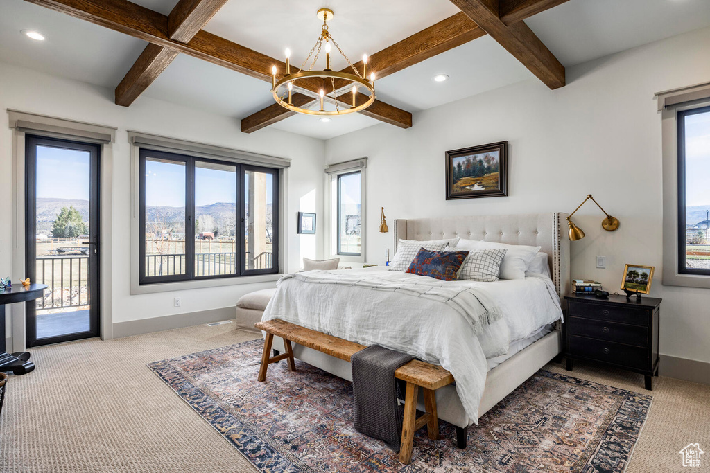 Bedroom featuring an inviting chandelier, coffered ceiling, light colored carpet, and access to exterior