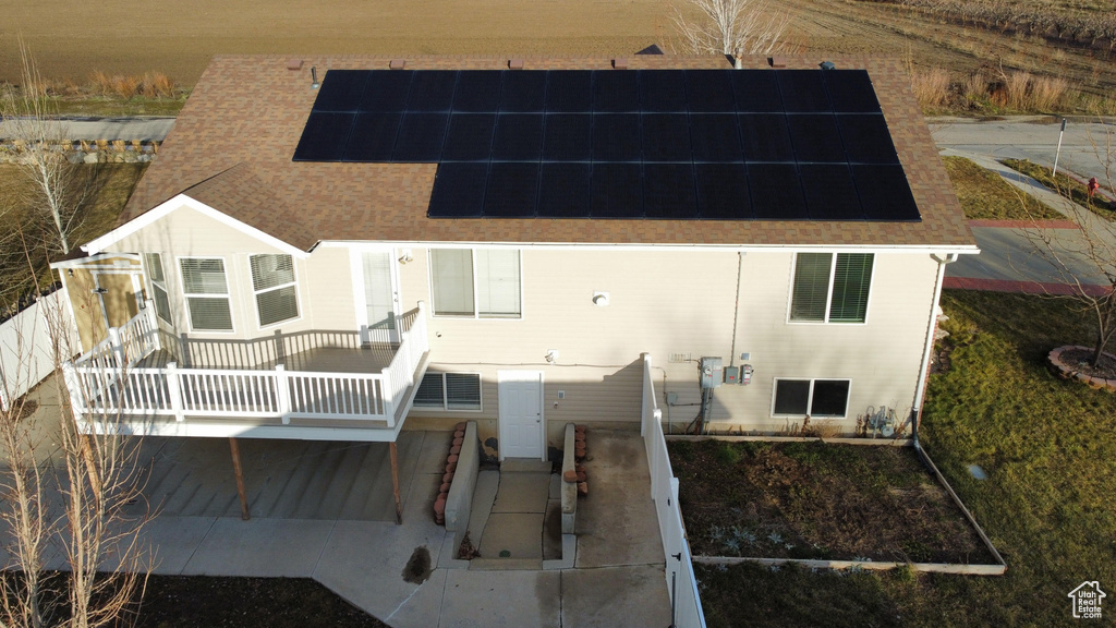 Back of house featuring solar panels and a deck