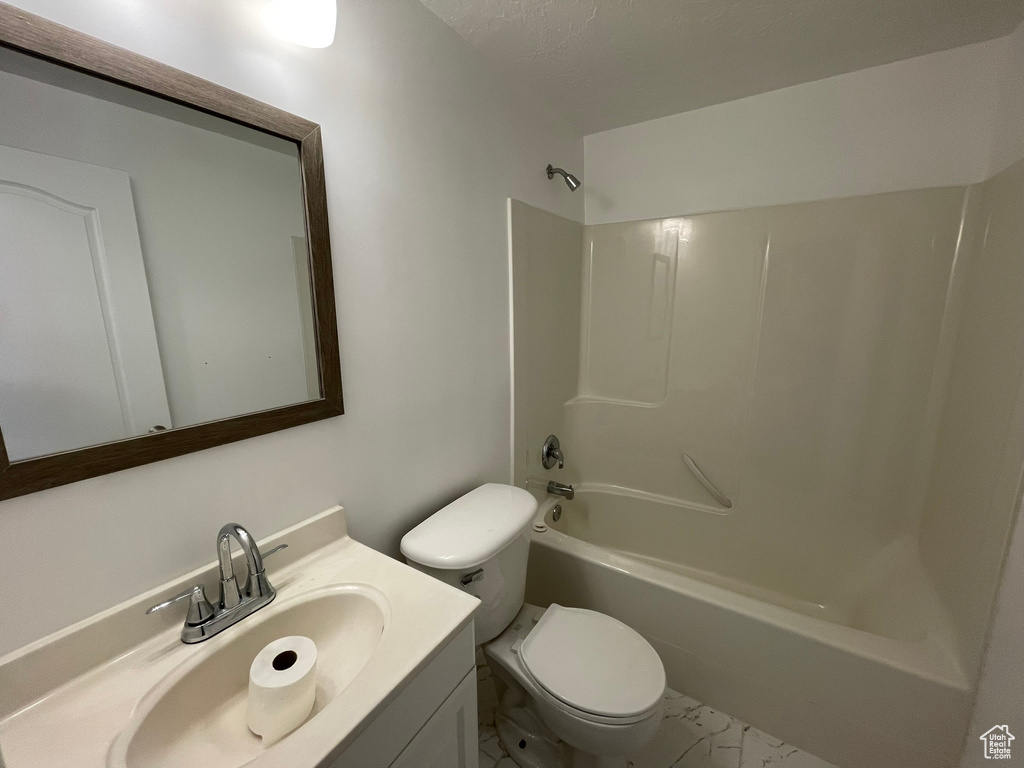 Full bathroom featuring shower / bath combination, vanity, a textured ceiling, toilet, and tile flooring