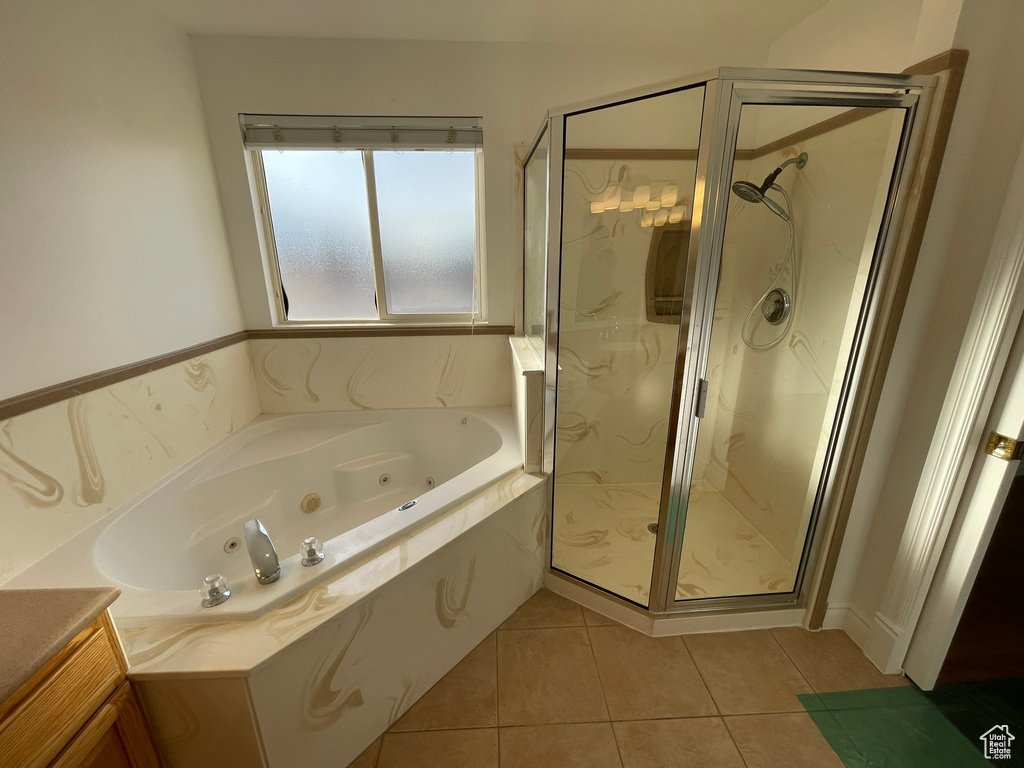 Bathroom with vanity, shower with separate bathtub, and tile flooring