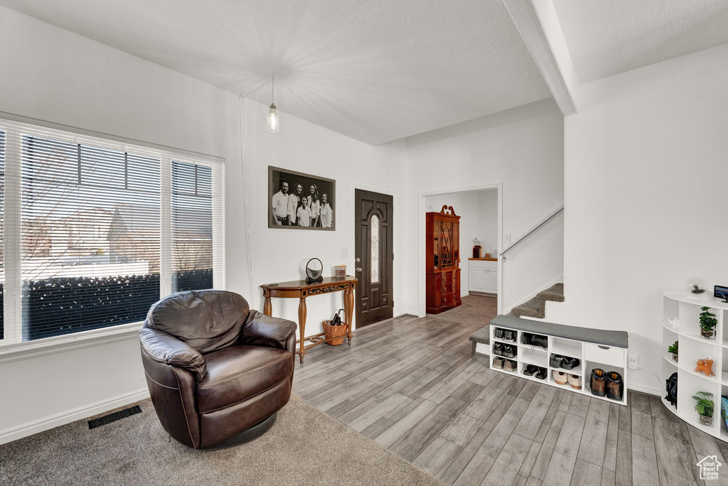 Sitting room with light hardwood / wood-style floors and beam ceiling