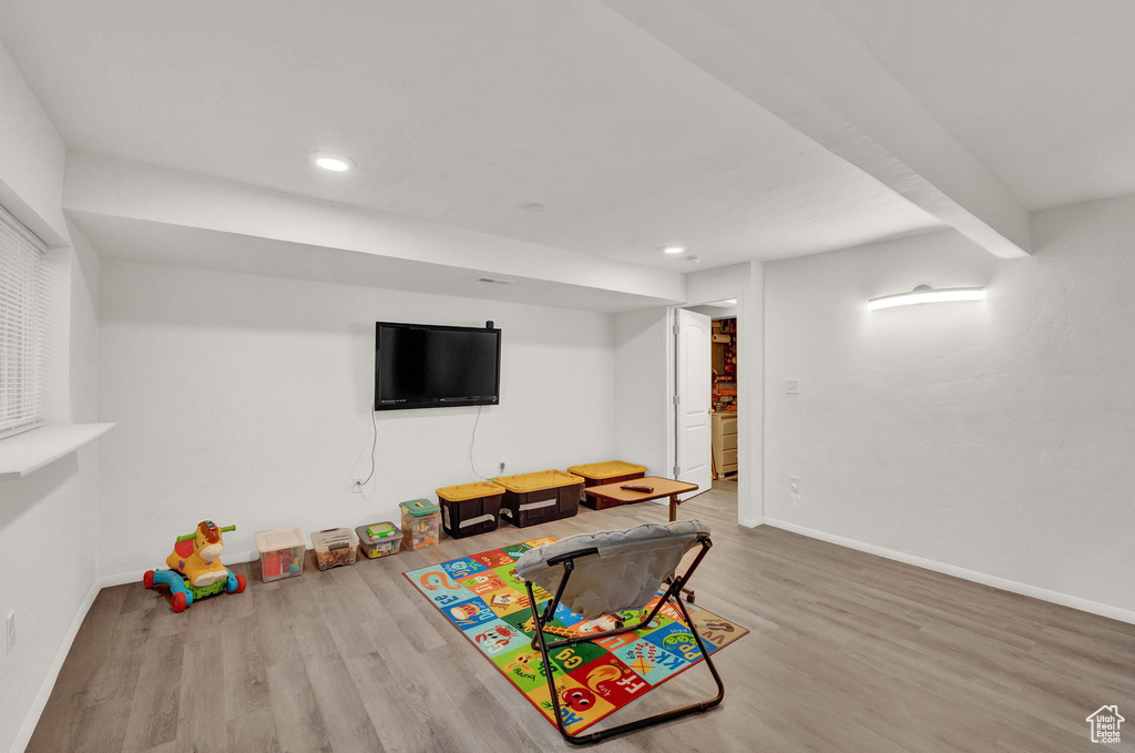 Game room featuring light hardwood / wood-style floors and beamed ceiling