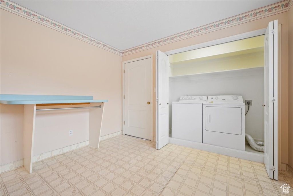 Laundry room with light tile flooring, hookup for an electric dryer, and washing machine and dryer