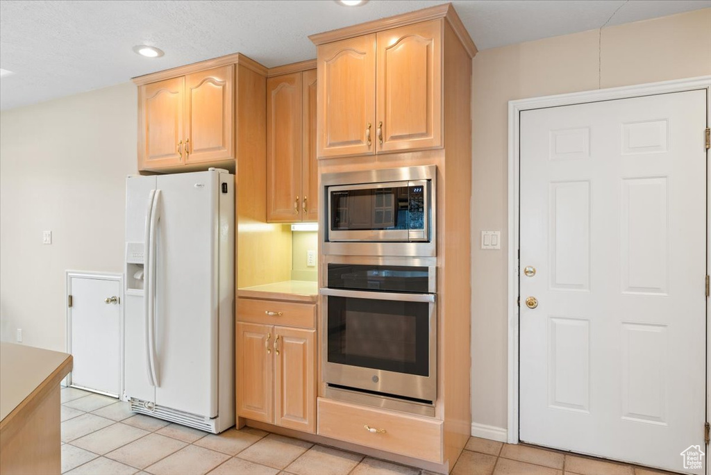 Kitchen featuring appliances with stainless steel finishes, light tile floors, and light brown cabinets