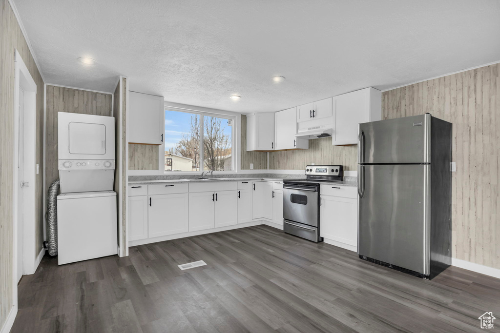 Kitchen with white cabinets, dark hardwood / wood-style flooring, electric range, and stainless steel fridge