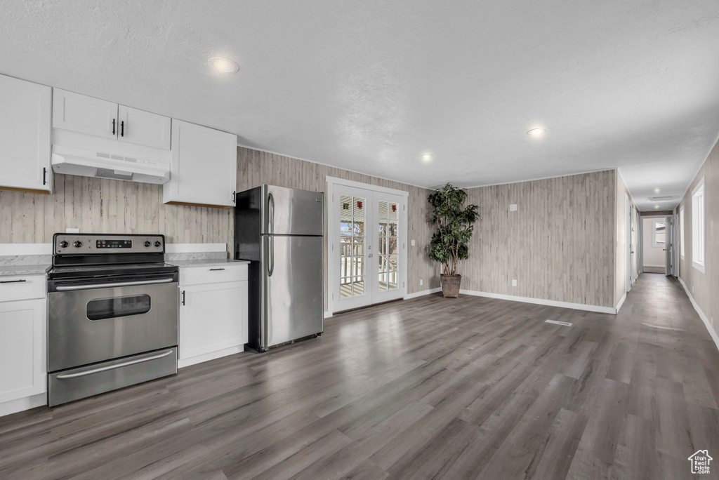 Kitchen with plenty of natural light, dark hardwood / wood-style flooring, stainless steel appliances, and white cabinets