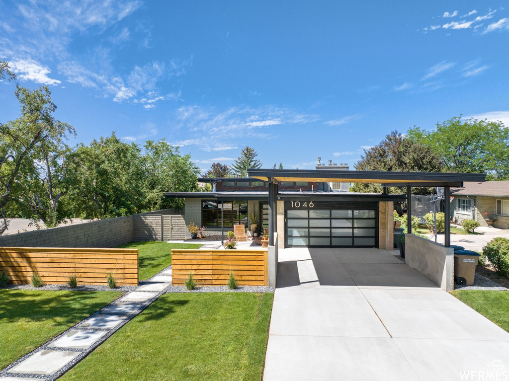 Contemporary home featuring a front lawn and a carport