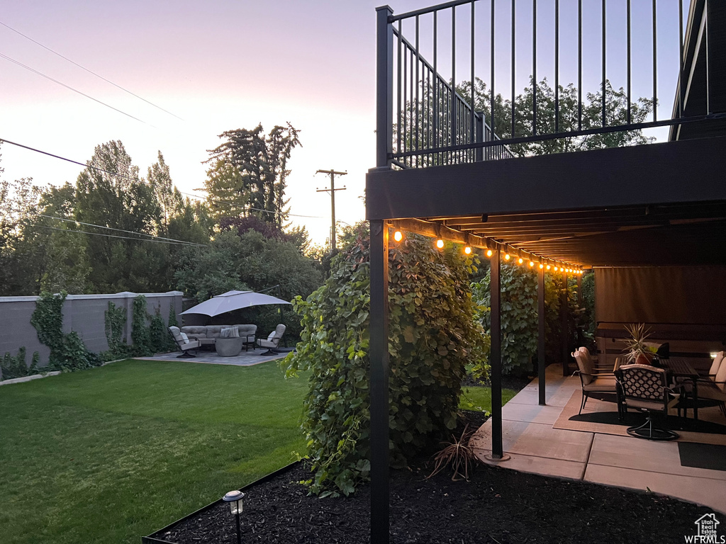 Patio terrace at dusk with a lawn and an outdoor hangout area