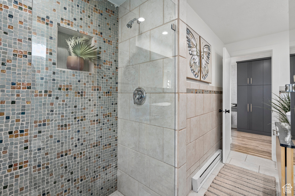 Bathroom with tiled shower and tile flooring