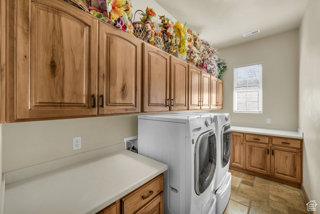 Washroom featuring washer hookup, light tile floors, separate washer and dryer, and cabinets
