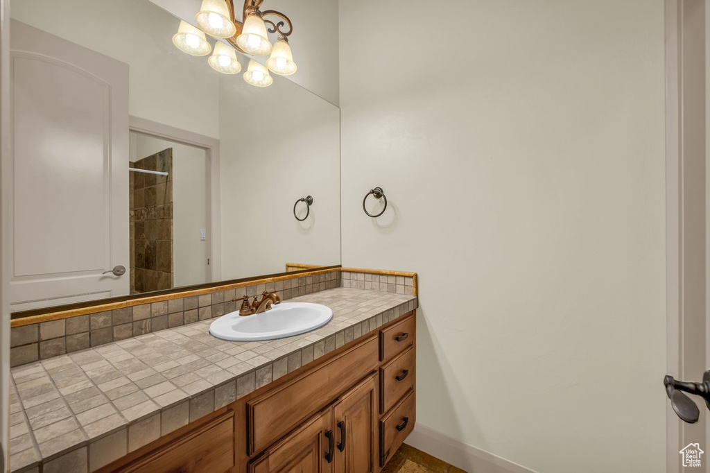Bathroom with a chandelier and vanity with extensive cabinet space
