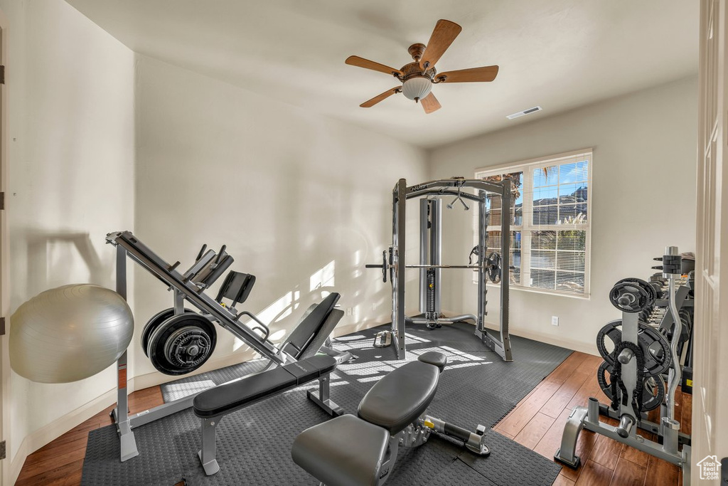 Workout room with dark wood-type flooring and ceiling fan
