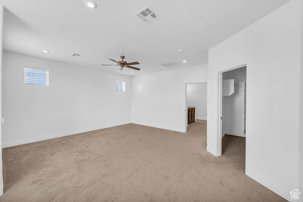 Empty room with light carpet and ceiling fan