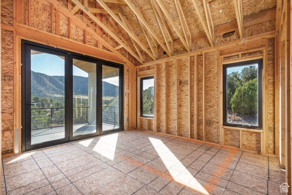 Interior space with plenty of natural light, lofted ceiling, tile flooring, and a mountain view