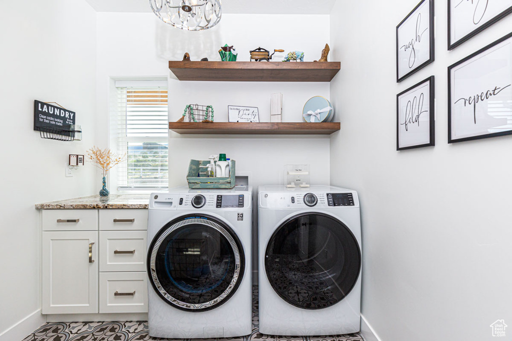 Laundry room with an inviting chandelier, cabinets, light tile floors, and independent washer and dryer