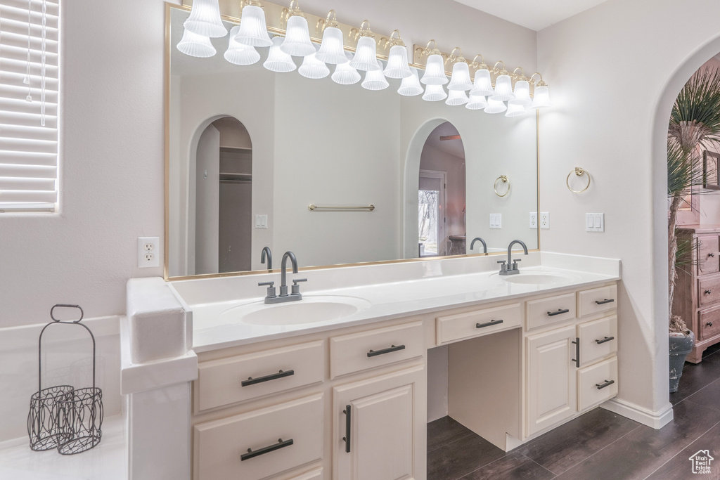 Bathroom with wood-type flooring, oversized vanity, and double sink