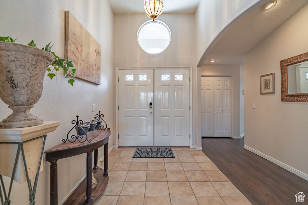 Foyer entrance featuring light hardwood / wood-style floors and a high ceiling