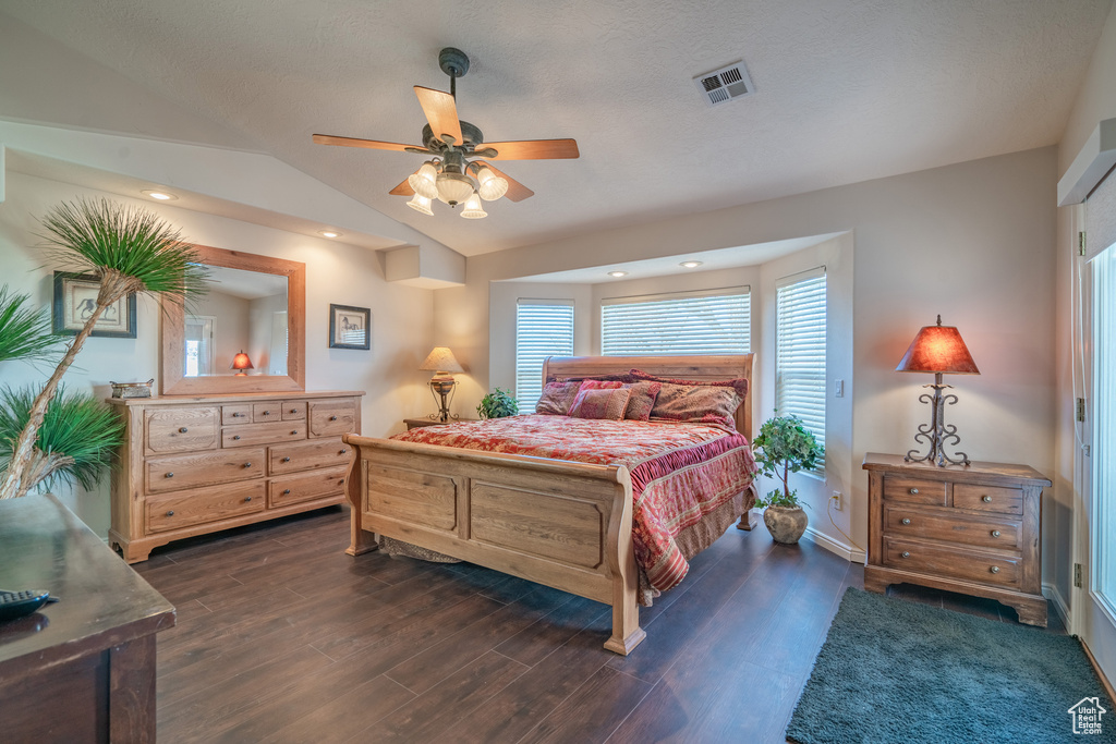 Bedroom featuring dark hardwood / wood-style flooring, ceiling fan, and lofted ceiling