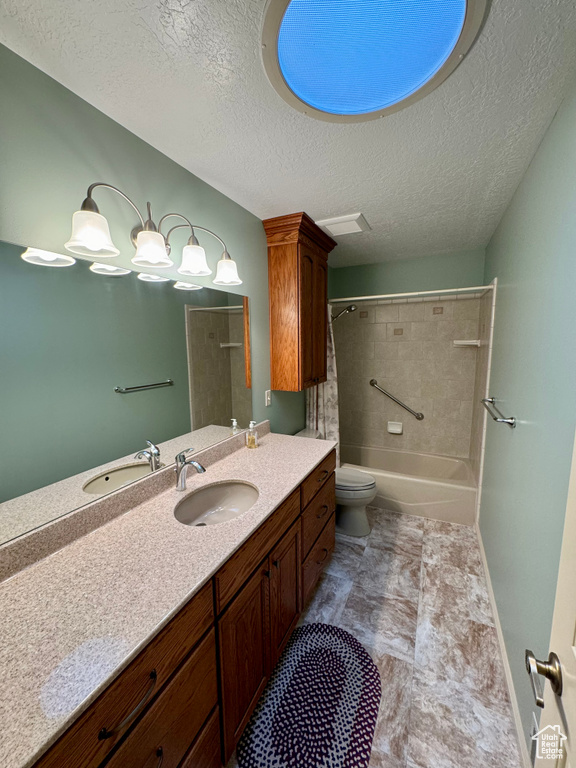 Full bathroom with a textured ceiling, vanity, bathing tub / shower combination, toilet, and tile floors