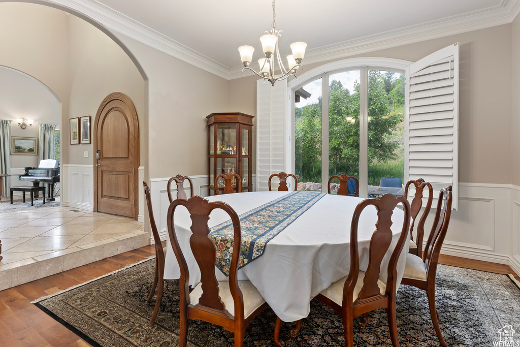 Dining space featuring a chandelier, ornamental molding, and light hardwood / wood-style flooring